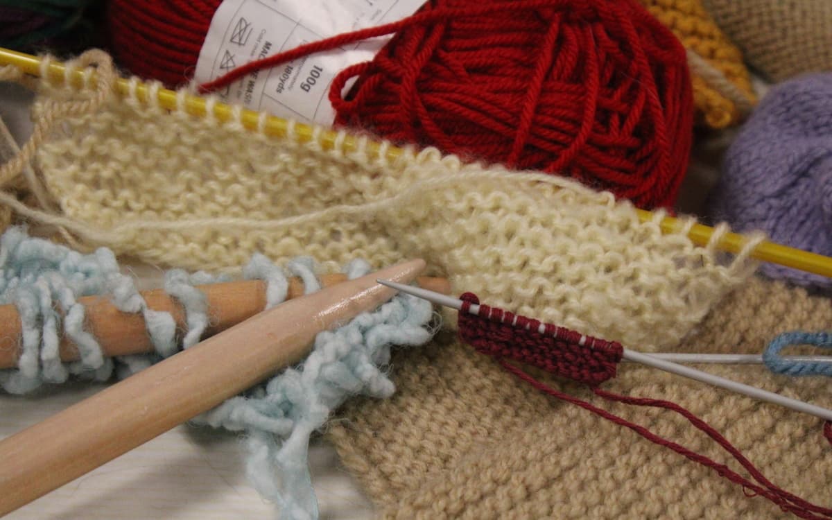 Photographie de matériels de tricot : aiguilles, laine, mailes etc. prise lors d'un atelier.